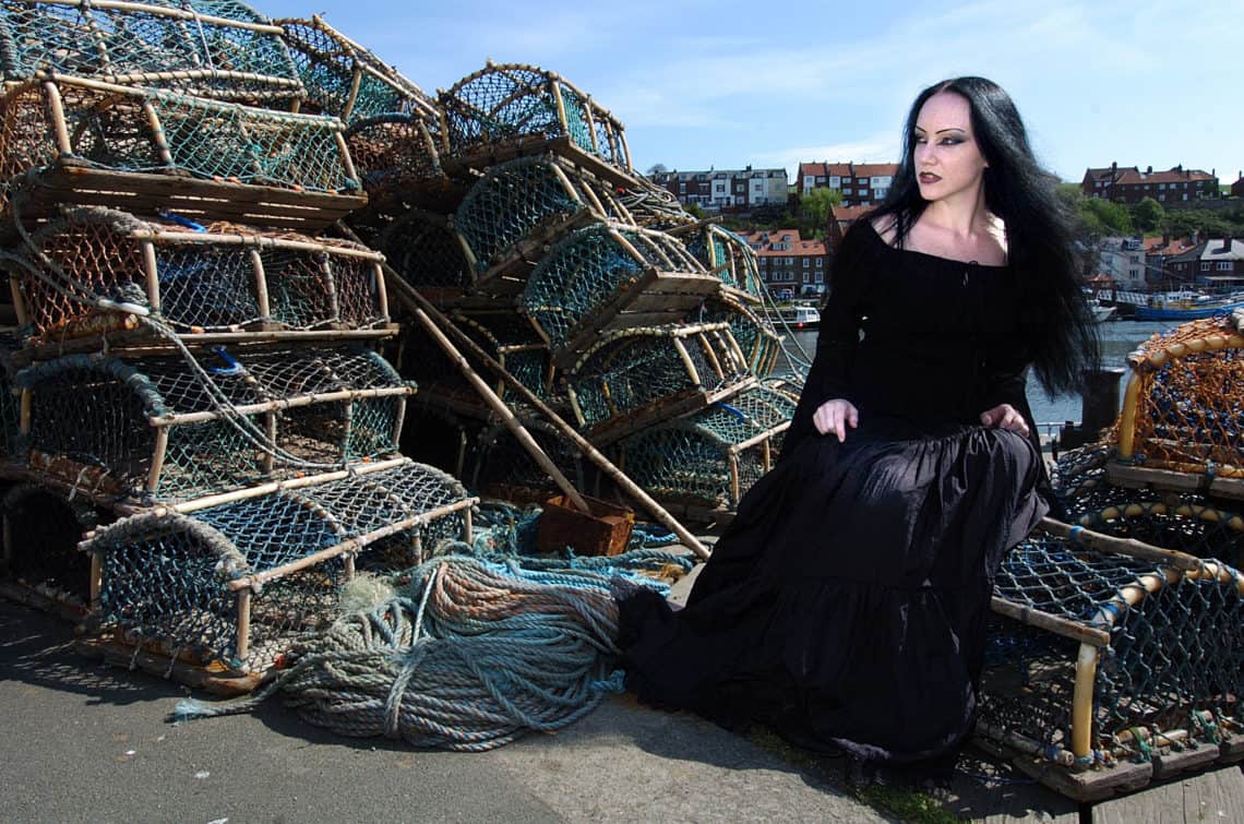 woman goth sitting by lobster traps