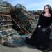 woman goth sitting by lobster traps