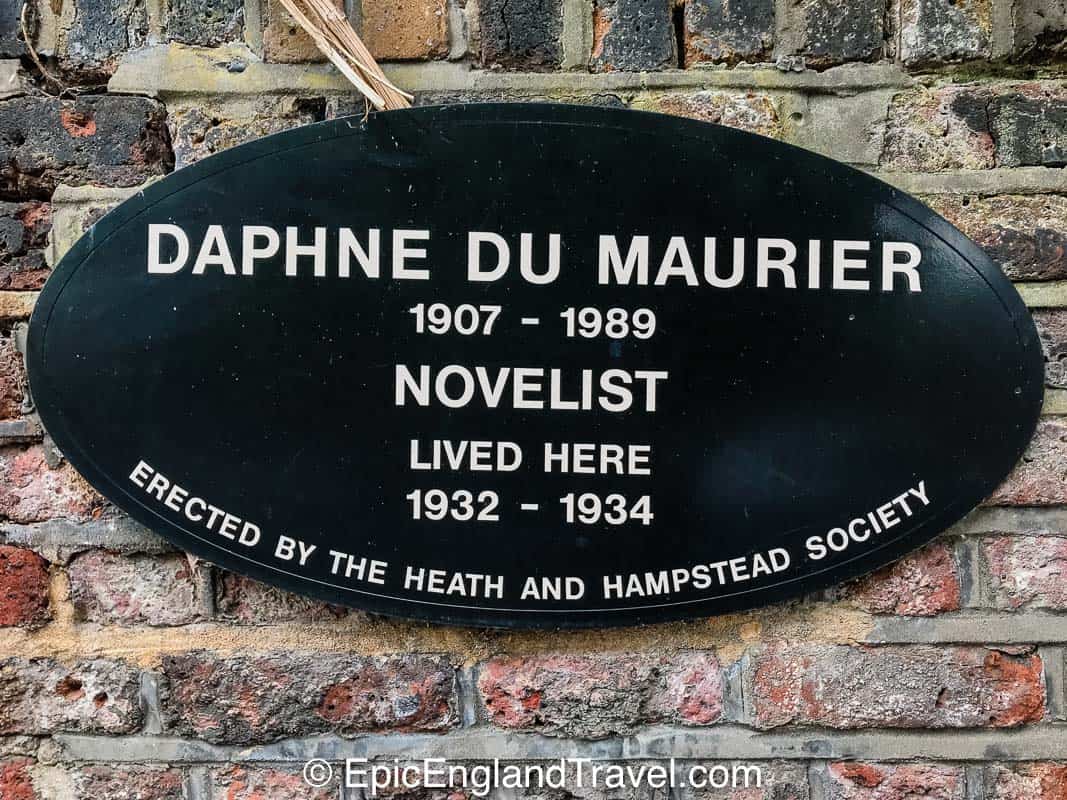 A badge on the side of a building in Hampstead indicating the novelist Daphne du Maurier lived there in the past.