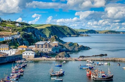 cornwall coastline with fishing boats and village