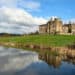 Ripley Castle reflected in a pond and green landscaping